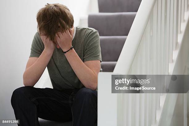 a teenage boy crying - kopf in den händen stock-fotos und bilder