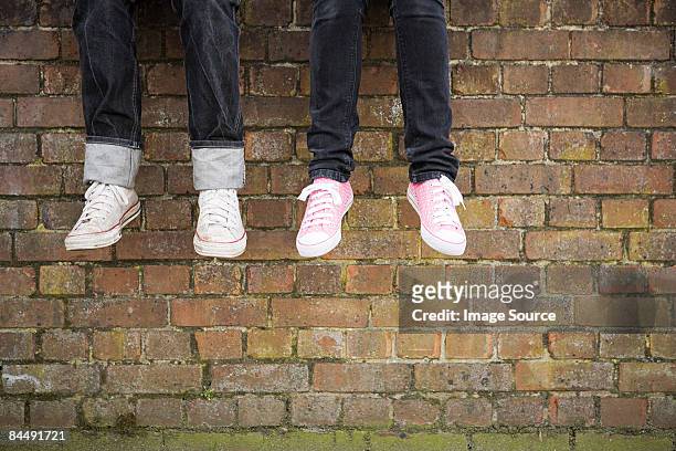 legs of teenagers on wall - girlfriend feet stock pictures, royalty-free photos & images