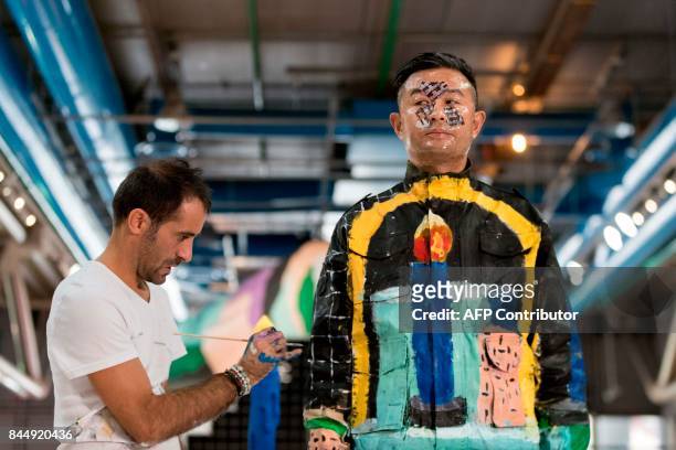 Chinese artist Liu Bolin takes part in a performance with a "Galerie Party" set, created by designers Gaelle Gabillet et Stephane Villard, during an...