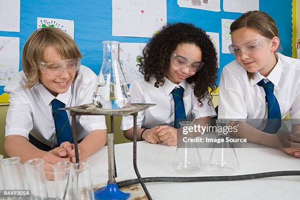 students in chemistry class - bunsen burner stockfoto's en -beelden