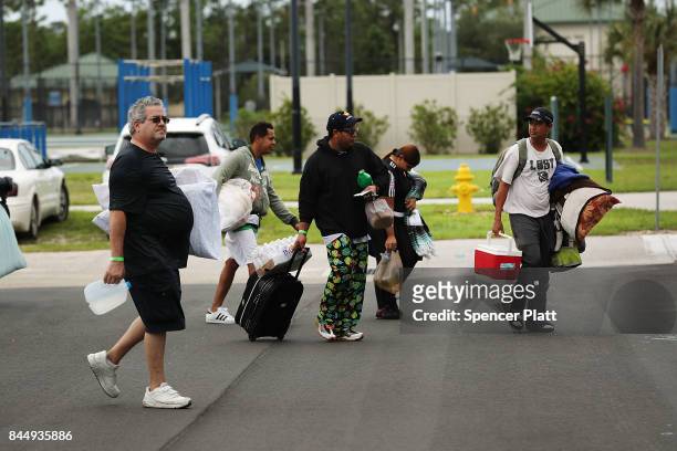 People arrive at a shelter at Alico Arena where thousands of Floridians are hoping to ride out Hurricane Irma on September 9, 2017 in Fort Myers,...