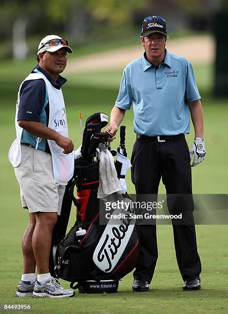 Aron Price of Australia pulls a club from his bag while alongside his caddie during the first round of the Sony Open at Waialae Country Club on...