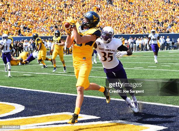 David Sills V of the West Virginia Mountaineers makes a touchdown catch in front of Chris Love of the East Carolina Pirates during the second quarter...