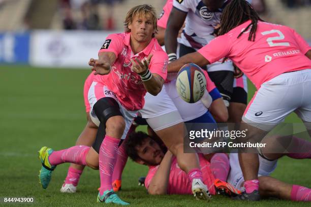 Stade Francais's South African scrumhalf Charl McLeod passes the ball during the warm up of the French Top 14 rugby union match between...
