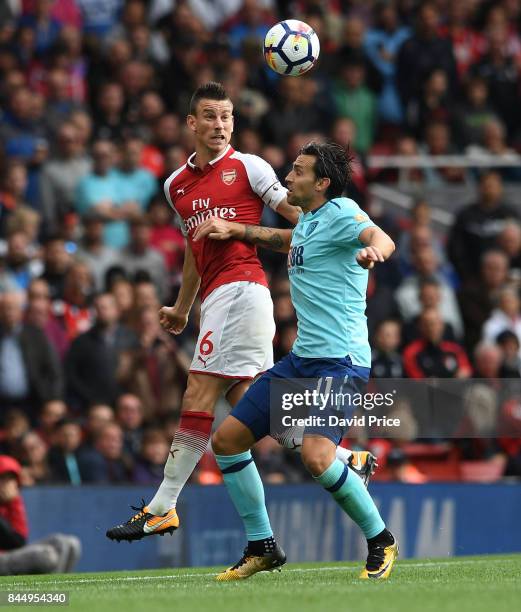 Laurent Koscielny of Arsenal heads the ball under pressure from Charlie Daniels of Bournemouth during the Premier League match between Arsenal and...