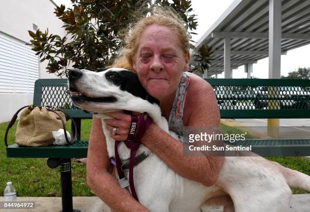 Laureen Cikora evacuates her RV in Davie, Fla., with her dog, Spice, to a hurricane shelter that allows pets as powerful Hurricane Irma heads toward...