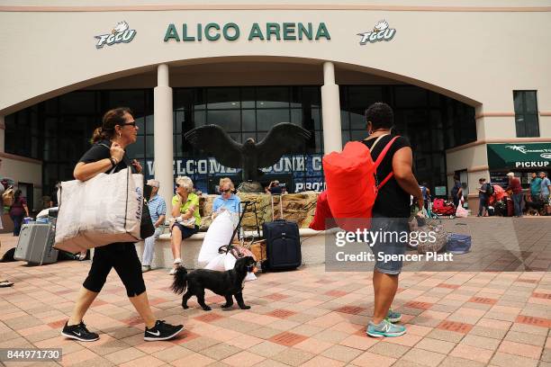 People arrive, many with their animals, a shelter at Alico Arena where thousands of Floridians are hoping to ride out Hurricane Irma on September 9,...