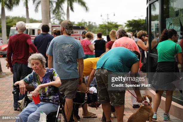 People arrive, many with their animals, a shelter at Alico Arena where thousands of Floridians are hoping to ride out Hurricane Irma on September 9,...