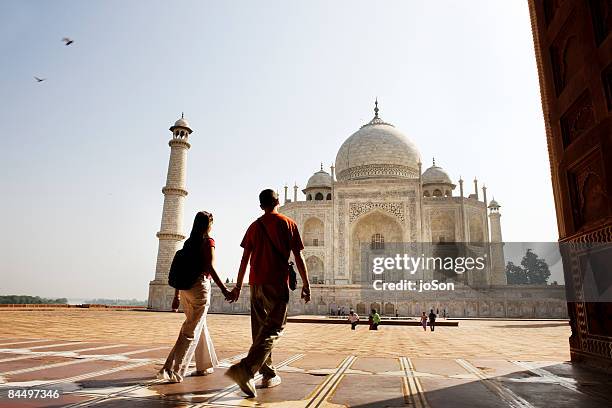 young couple walking in the taj mahal courtyard - india tourism stockfoto's en -beelden