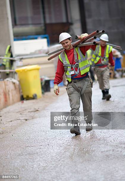 construction workers carry scaffolding - carry foundation stock-fotos und bilder