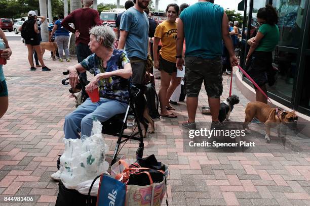 People arrive, many with their animals, a shelter at Alico Arena where thousands of Floridians are hoping to ride out Hurricane Irma on September 9,...