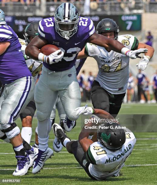 Running back Mike McCoy of the Kansas State Wildcats rushes over the top of free safety AJ McDonald of the Charlotte 49ers for a touchdown during the...