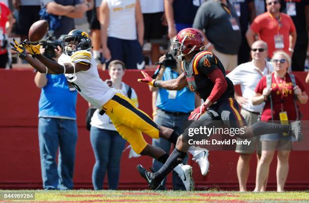 Wide receiver Ihmir Smith-Marsette of the Iowa Hawkeyes pulls in a touchdown pass as defensive back Evrett Edwards of the Iowa State Cyclones defends...