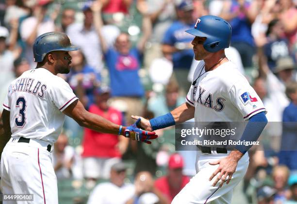 Delino DeShields of the Texas Rangers greets Will Middlebrooks of the Texas Rangers who scored on a double by Brett Nicholas in the 5th inning of a...