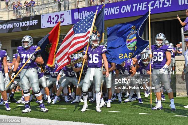 Players Jesse Ertz, Dalton Risner and Breontae Matthews of the Kansas State Wildcats gets set to lead the Wildcats out onto the field against the...