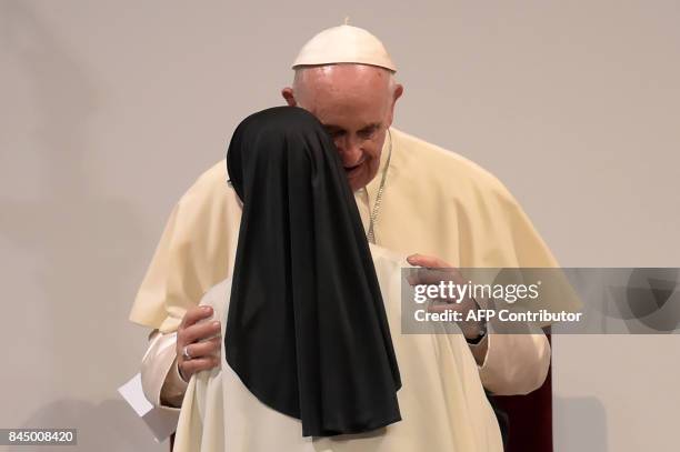 Pope Francis greets a nun during a meeting with religious people at La Macarena convention centre -a former bullring- in Medellin, Colombia, on...