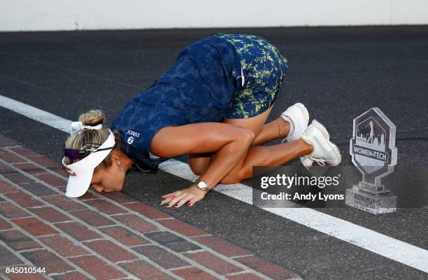 Lexi Thompson kisses the Yard of bricks at the Indianapolis Motor Speedway after winning the Indy Women In Tech Championship-Presented By Guggenheim...