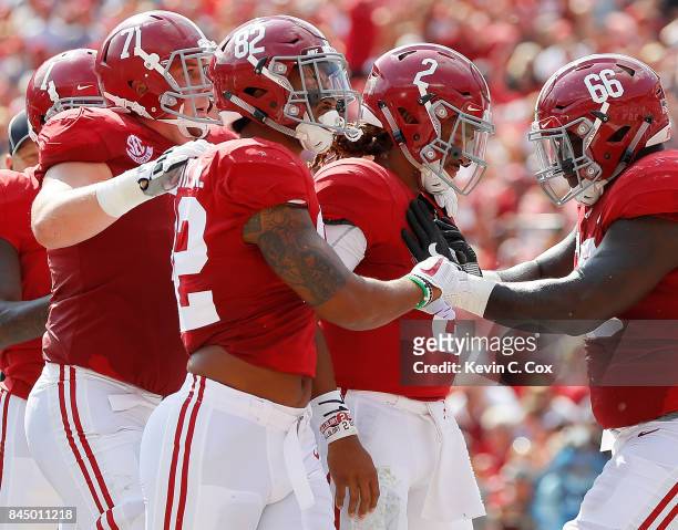 Jalen Hurts of the Alabama Crimson Tide reacts after rushing for a touchdown against the Fresno State Bulldogs with Irv Smith Jr. #82, Lester Cotton...