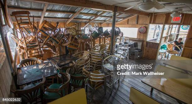 Emily Steele stacks bar chairs in a room at the Riverside Cafe in preparation for Hurricane Irma September 9, 2017 in the Florida panhandle town of...