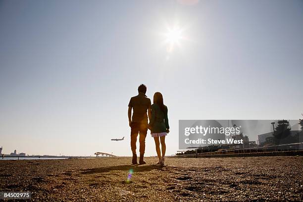 couple holding hands and watching aircraft land - casal de idade mediana - fotografias e filmes do acervo