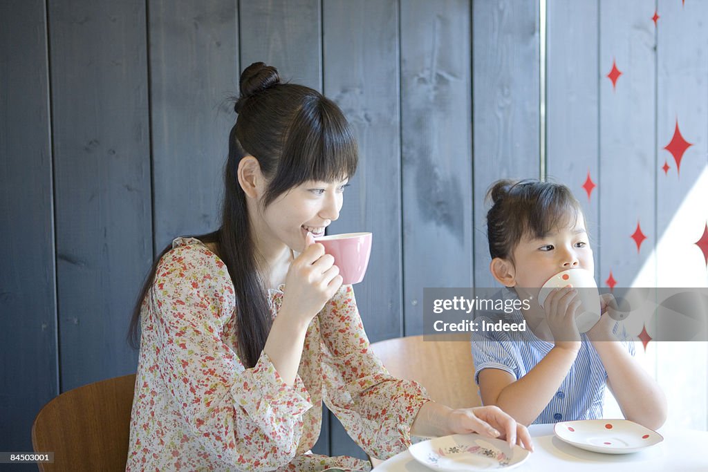 Mother and daughter sitting and drinking tea