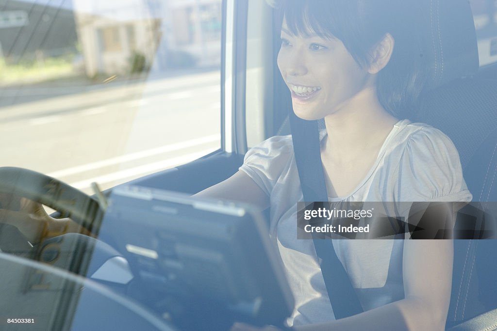 Japanese woman driving car, smiling