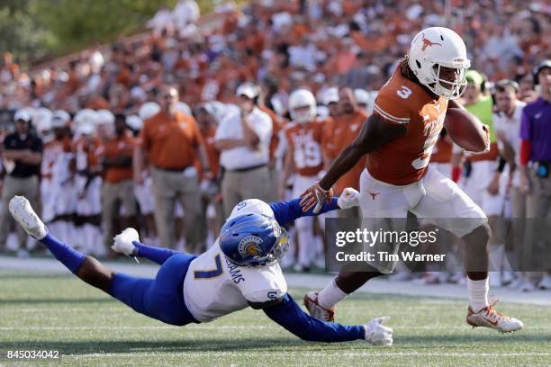 Armanti Foreman of the Texas Longhorns gets past the tackle attempt by David Williams of the San Jose State Spartans in the fourth quarter at Darrell...