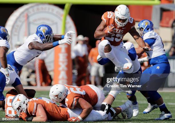 Chris Warren III of the Texas Longhorns leaps over defenders in the third quarter against the San Jose State Spartans at Darrell K Royal-Texas...