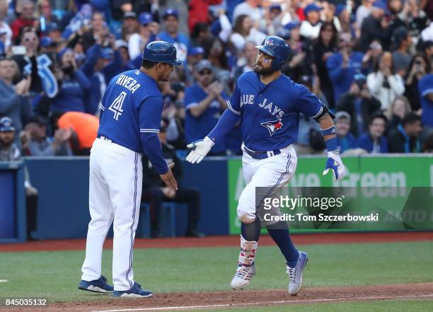 Kevin Pillar of the Toronto Blue Jays is congratulated by third base coach Luis Rivera after hitting a solo home run in the sixth inning during MLB...