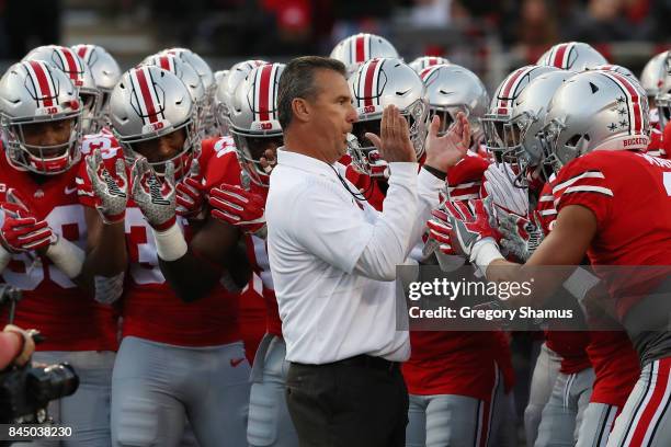 Head coach Urban Meyer of the Ohio State Buckeyes stands with his players before the game against the Oklahoma Sooners at Ohio Stadium on September...