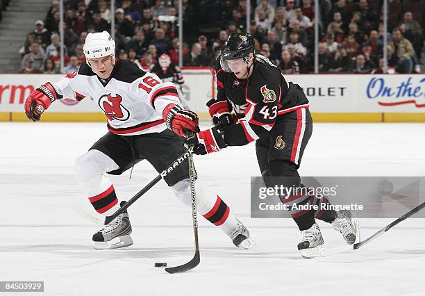 Peter Regin of the Ottawa Senators stickhandles the puck against Bobby Holik of the New Jersey Devils reaches to stick check at Scotiabank Place on...
