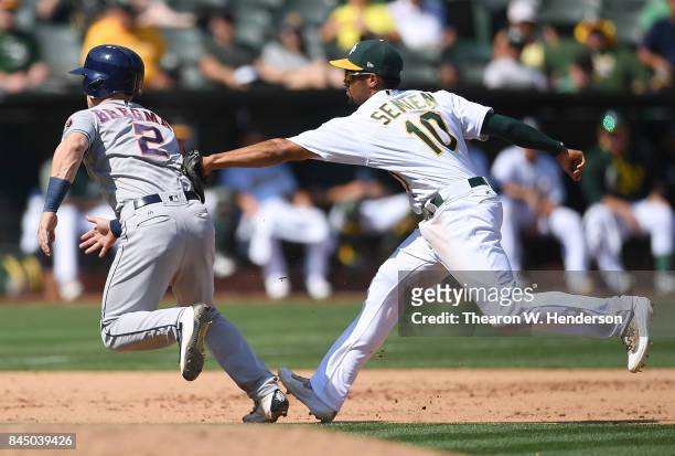 Alex Bregman of the Houston Astros caught in a rundown gets tagged out by Marcus Semien of the Oakland Athletics in the top of the fifth inning...