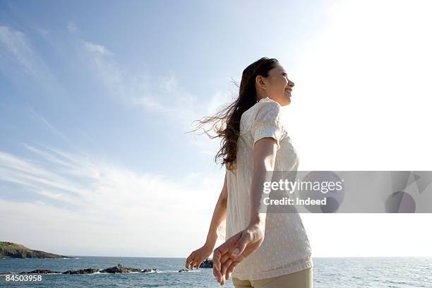young woman relaxing by the sea - 息抜き ストックフォトと画像