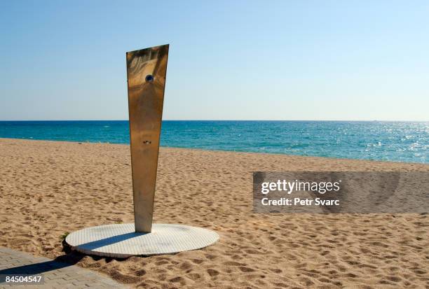 shower on empty beach, spain - maresme stock pictures, royalty-free photos & images