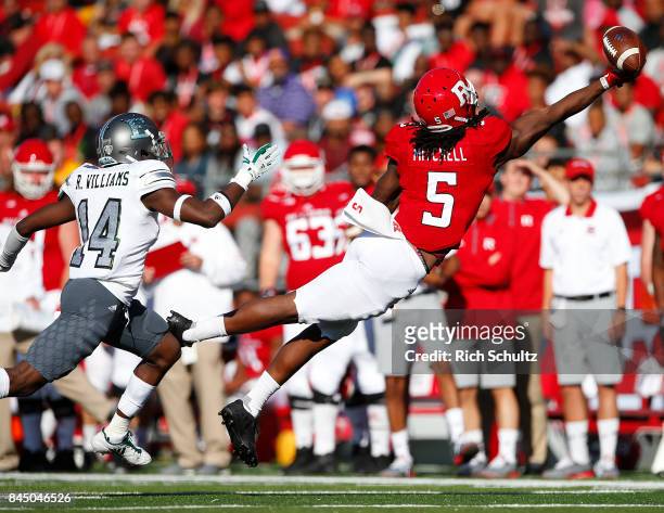 Damon Mitchell of the Rutgers Scarlet Knights reaches for the ball but can't make the catch as Ross Williams of the Eastern Michigan Eagles defends...