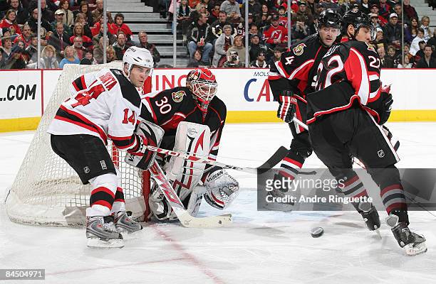 Brian Elliott, Chris Kelly and Chris Phillips of the Ottawa Senators defend against Brian Gionta of the New Jersey Devils as he looks for a rebound...