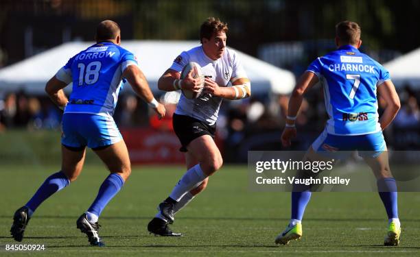 Jacob Emmitt of Toronto Wolfpack runs toward Danny Morrow and Lewis Charnock of Barrow Raiders during a Kingstone Press League 1 Super 8s match at...