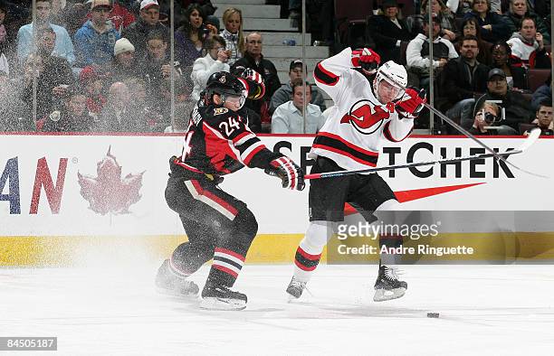 Anton Volchenkov of the Ottawa Senators checks John Madden of the New Jersey Devils off the puck at Scotiabank Place on January 27, 2009 in Ottawa,...