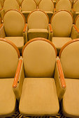 Cinema audience hall with golden row arranged armchairs