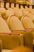 Cinema audience hall with golden row arranged armchairs