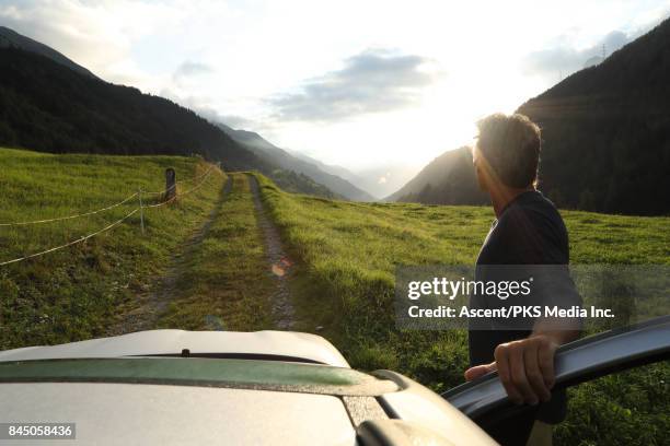 man leaves car on mountain track, sunrise - car top view photos et images de collection