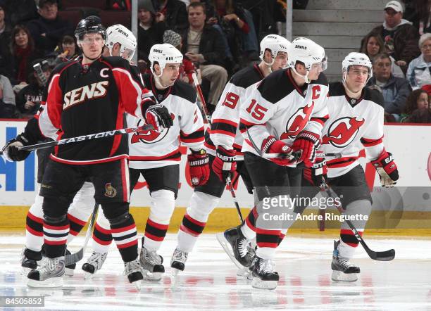 Daniel Alfredsson of the Ottawa Senators looks on as Jamie Langenbrunner of the New Jersey Devils skates away after celebrating a goal with teammates...