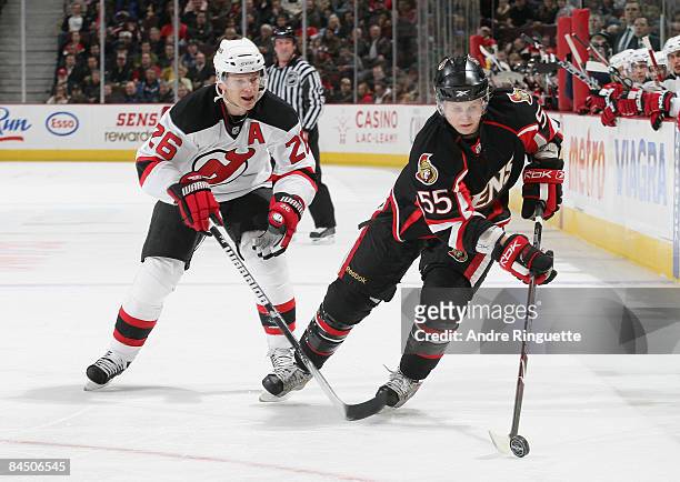 Brian Lee of the Ottawa Senators stickhandles the puck against Patrik Elias of the New Jersey Devils at Scotiabank Place on January 27, 2009 in...