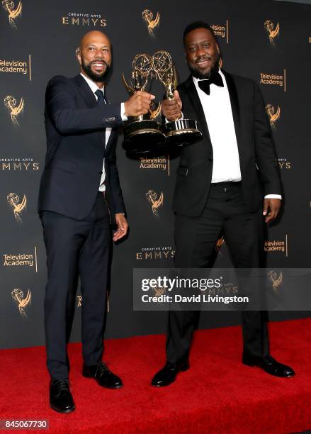 Hip-hop artist Common and pianist Robert Glasper pose in the press room with the award for outstanding original music and lyrics for "13th Song...