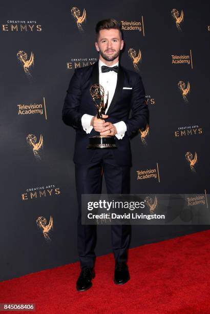 Dancer Travis Wall poses in the press room with the award for outstanding choreography for "So You Think You Can Dance" during the 2017 Creative Arts...