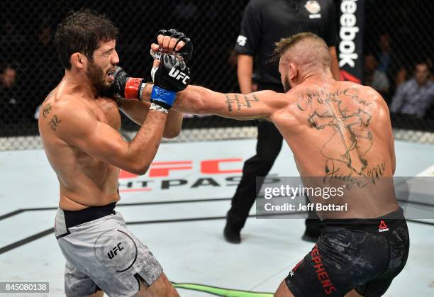 Jeremy Stephens punches Gilbert Melendez in their featherweight bout during the UFC 215 event inside the Rogers Place on September 9, 2017 in...