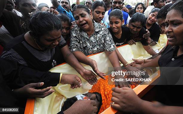 Family members mourn over the body of ethnic Indian Ananthan Kugan during a burial ceremony in Puchong outside Kuala Lumpur on January 28, 2009....