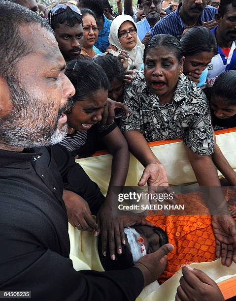 Family members mourn over the body of ethnic Indian Ananthan Kugan during a burial ceremony in Puchong outside Kuala Lumpur on January 28, 2009....
