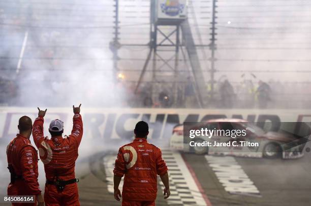 Chip Ganassi Racing crew members celebrate as Kyle Larson, driver of the Target Chevrolet, performs a burnout after winning the Monster Energy NASCAR...