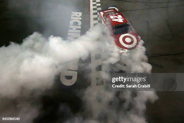 Kyle Larson, driver of the Target Chevrolet, celebrates with a burnout after winning the Monster Energy NASCAR Cup Series Federated Auto Parts 400 at...